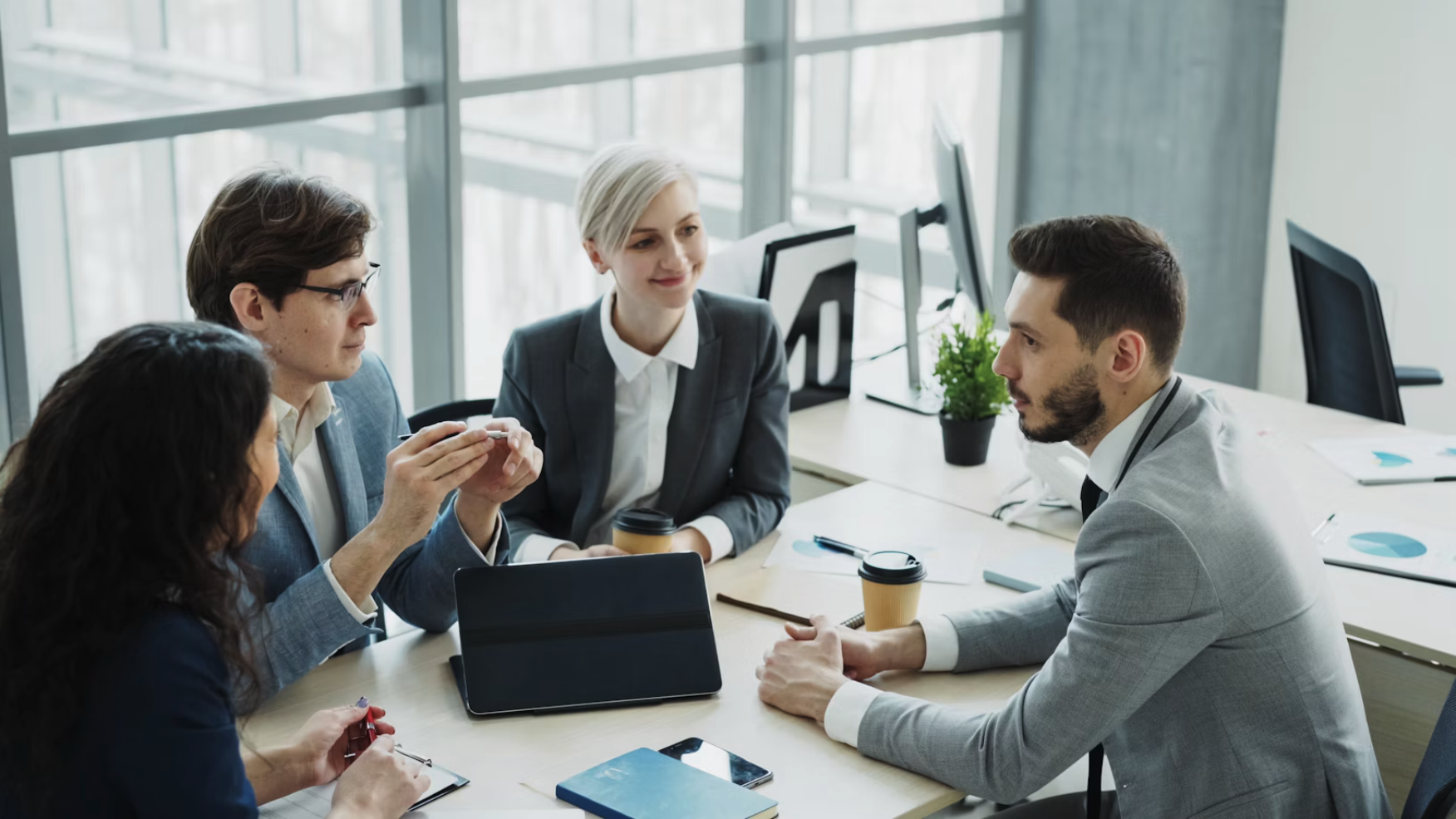 Reunión empresarial discutiendo métricas TAM SAM SOM con pirámide en presentación